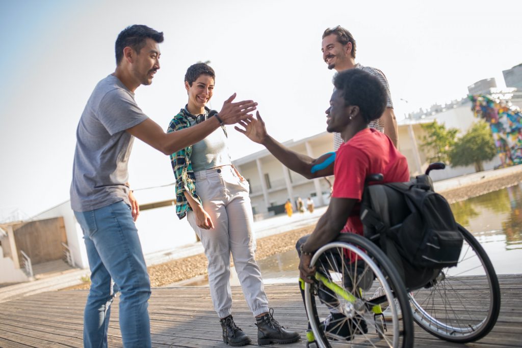 A Man Greeting another His Friend in a Wheelchair