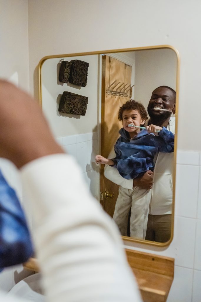 father and son brushing teeth in bathroom