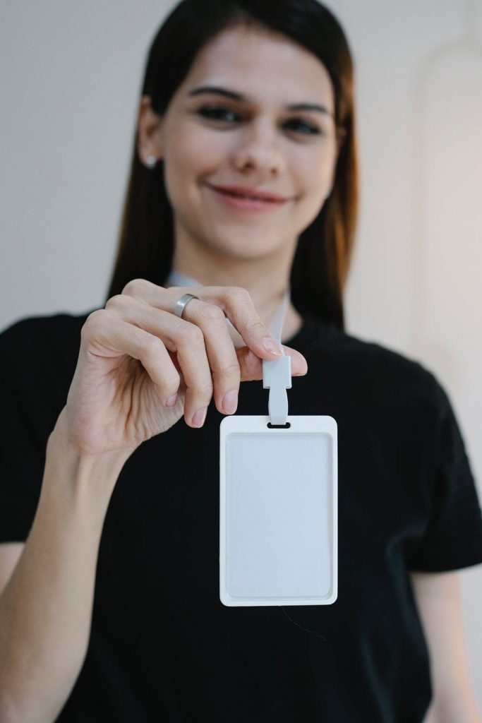 Cheerful woman showing blank name tag