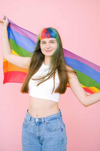 Image of a person holding a rainbow flag