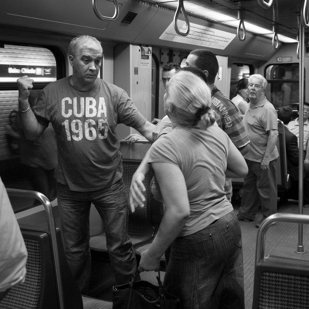 Man and woman posturing on a subway car.