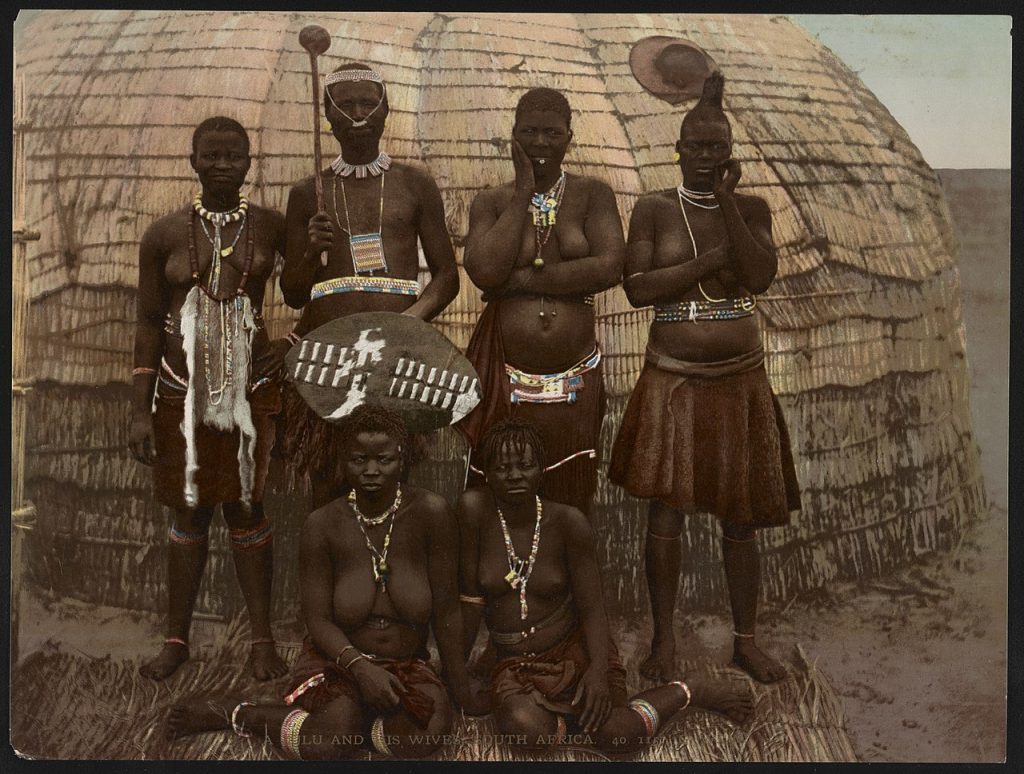 a zulu man stands with his wives.