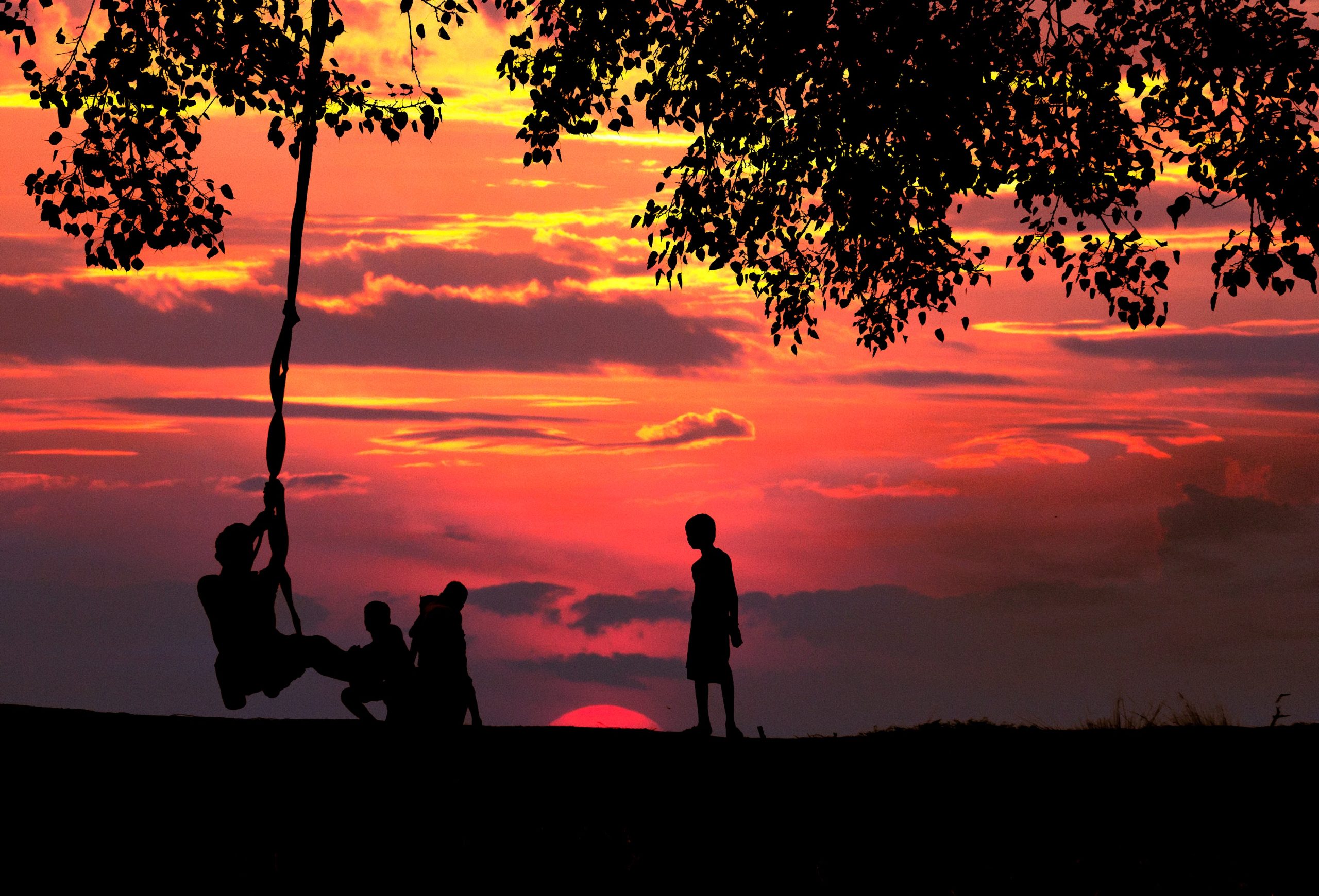 silhouettes of kids playing at sunset