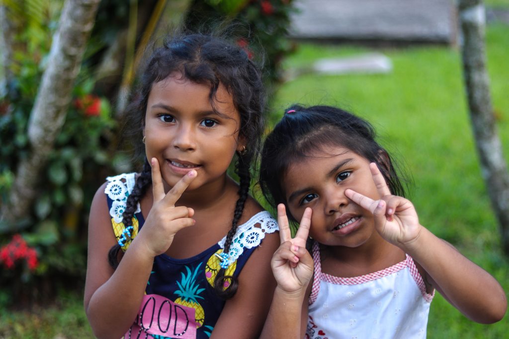 Picture of two children posing while making peace signs with their fingers