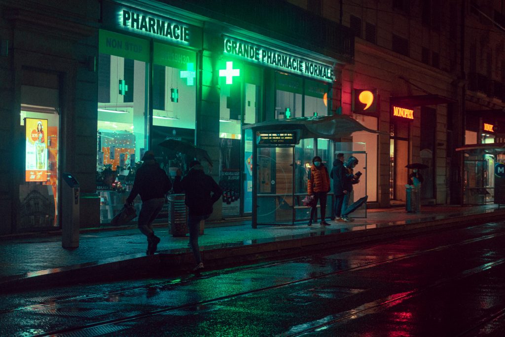 Pharmacy storefront in France at night.
