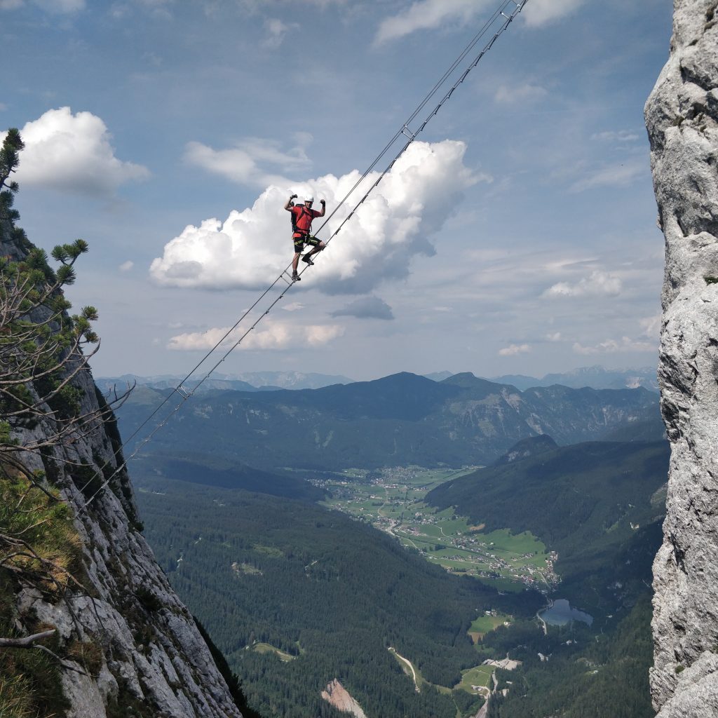 Man balancing on a wire between mountains