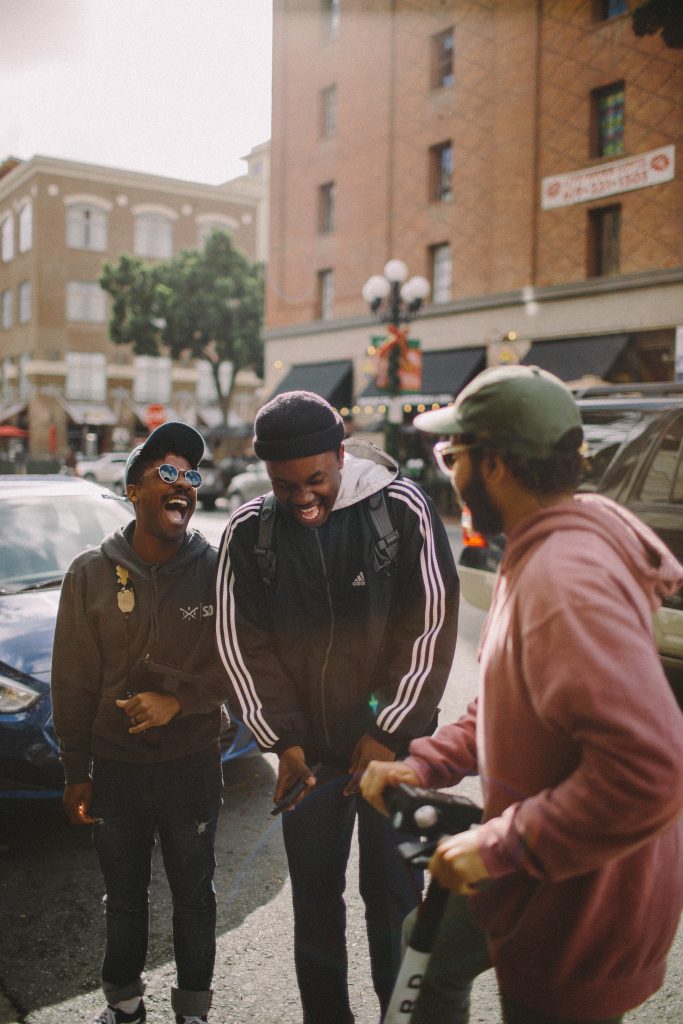 Three men in jackets laughing with each other