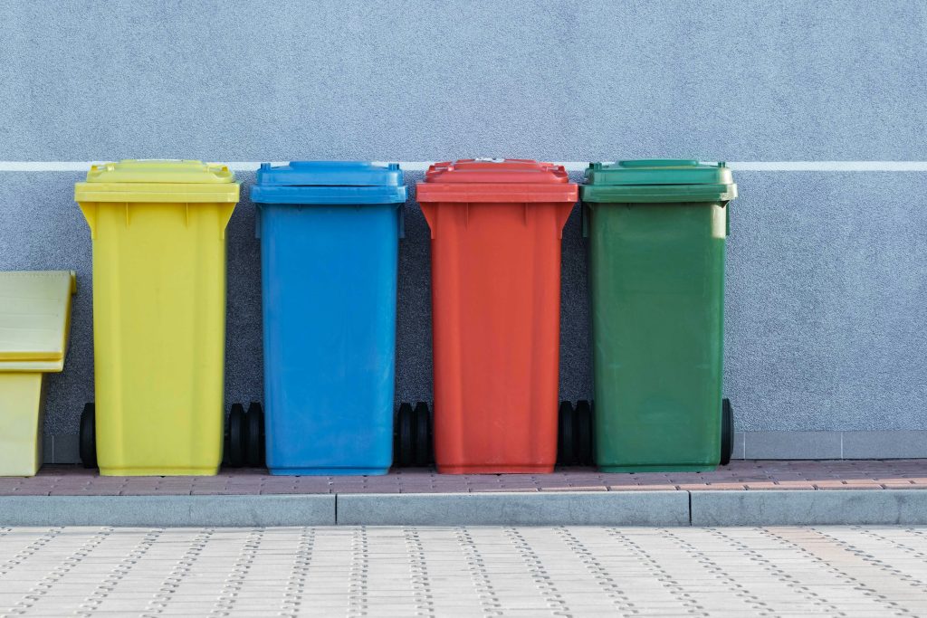 four assorted-color bins against a gray wall