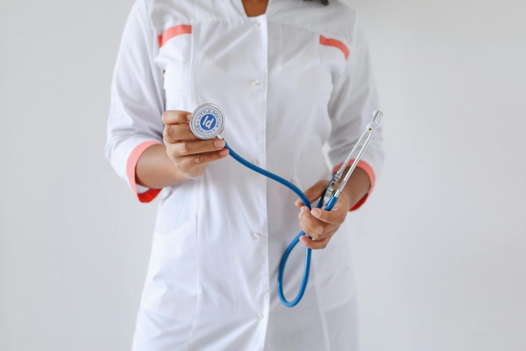 Person in White Button Up Shirt Holding Blue and Silver Stethoscope