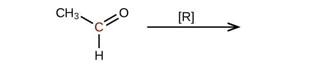 The left side of a reaction and arrow are shown. The arrow is labeled with an R in brackets. To the left of the arrow is a molecular structure that shows a central, red C atom. This C atom is bonded to a C H subscript 3 group, and H atom, and an O atom. It forms a double bond with the O atom.