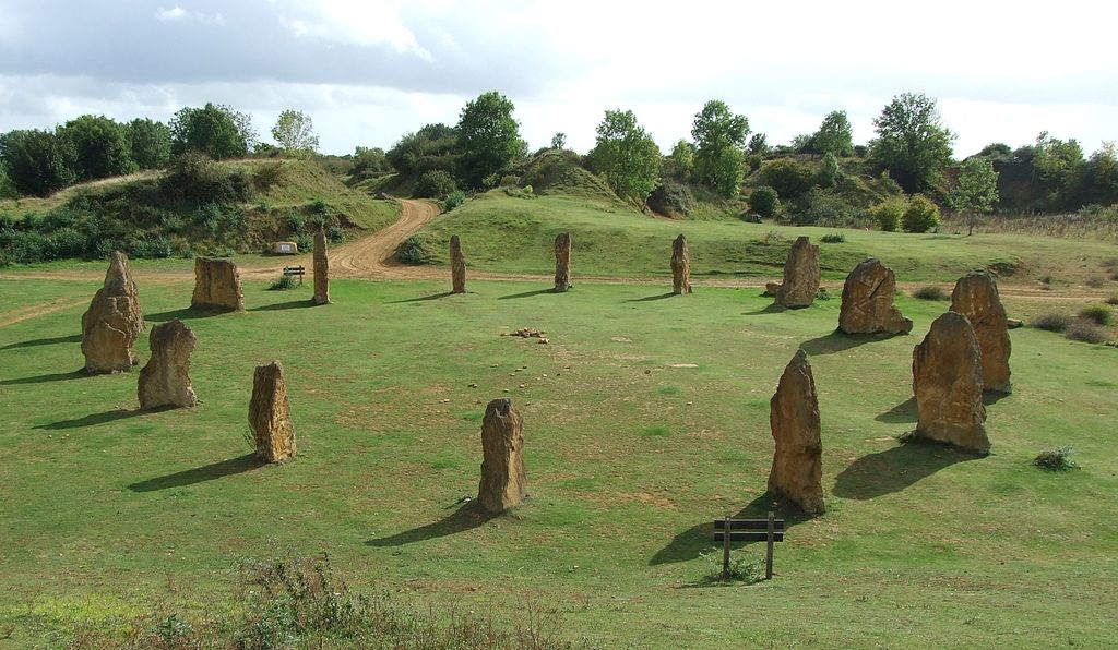 large rocks standing vertically and positioned in a large circle on a grassing field