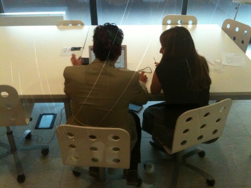 Researcher and user sit side-by-side at a table