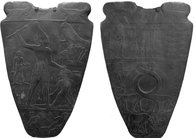 Two dark stone shields with carvings of Egyptian men and animals
