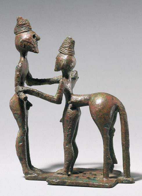 Stone male figure holding another with a horse rump and tail in dance hold