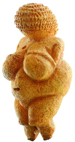 Yellow stone woman with curly hair and large breasts and stomach