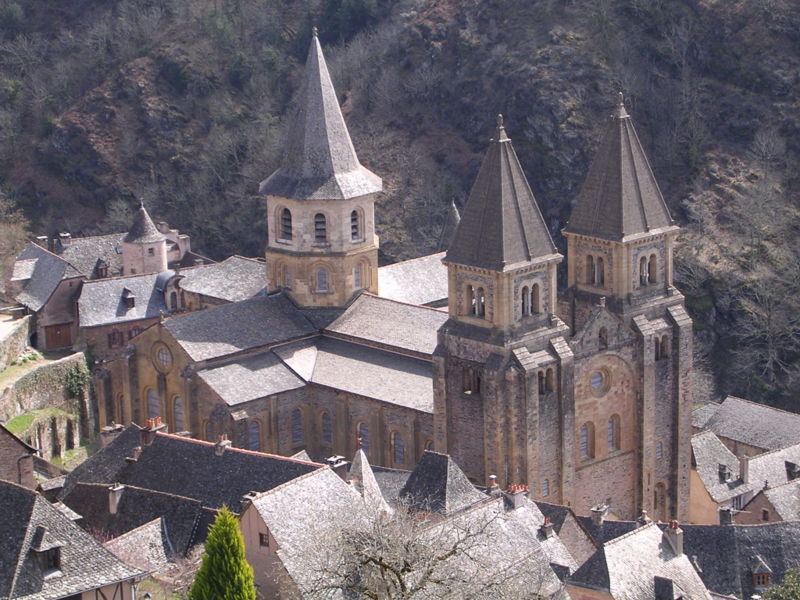 Three large steeples on a church in a mountain town