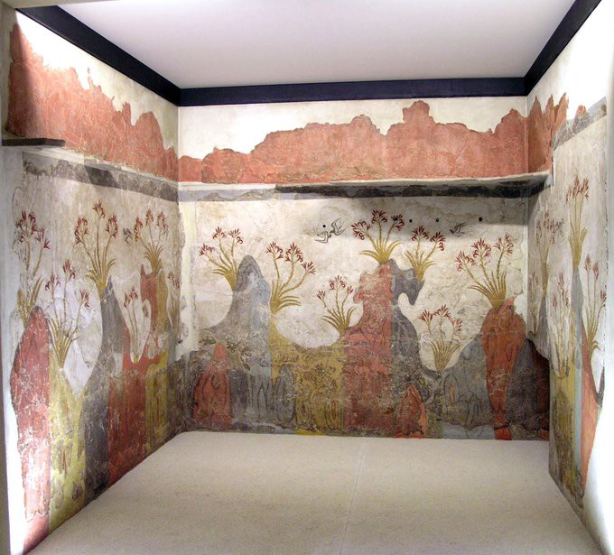Square room with walls painted with blue, yellow, and red hills with flowers