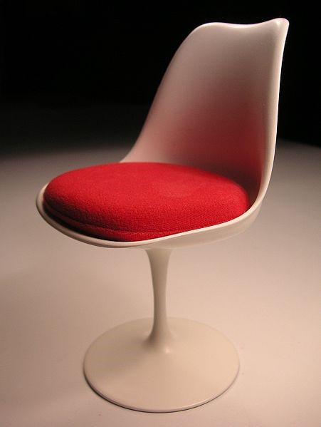 Round chair with a single leg and a red cushion