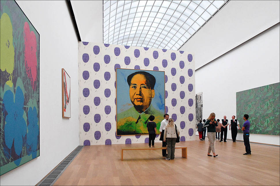 Large painting of Chinese man on polka dotted wall in museum