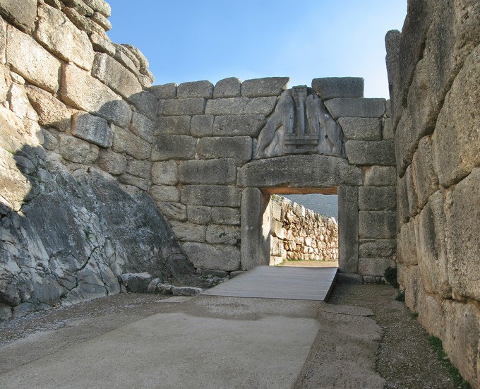 Large stone gate leading through a stone hall under blue sky