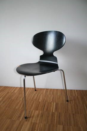 Black chair with three legs and oblong back