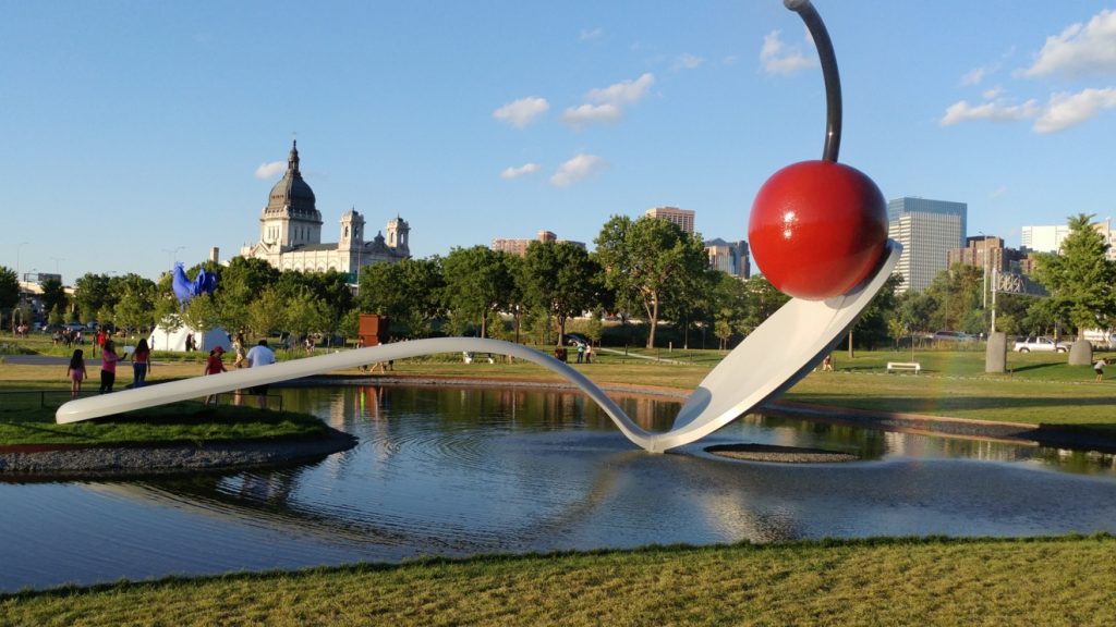 Enormous spoon bridge with a cherry on it in small pond