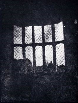 Dark photo with a ten-pane window in the center