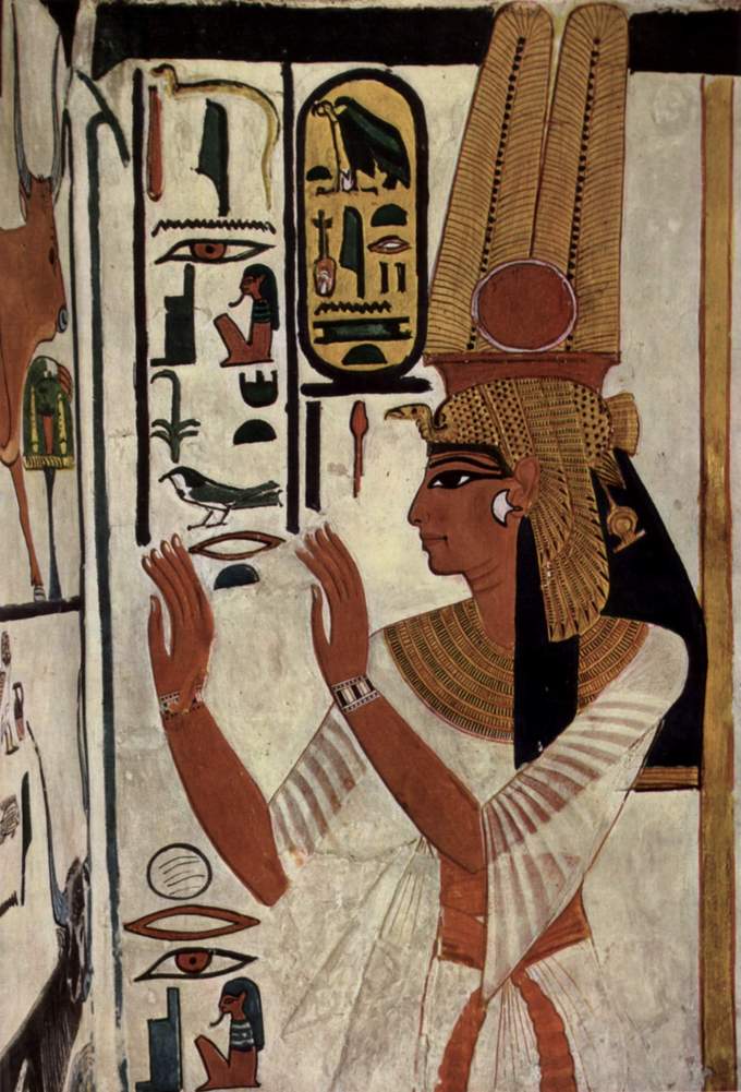 Wall painting of woman with a bird headdress looking at symbols