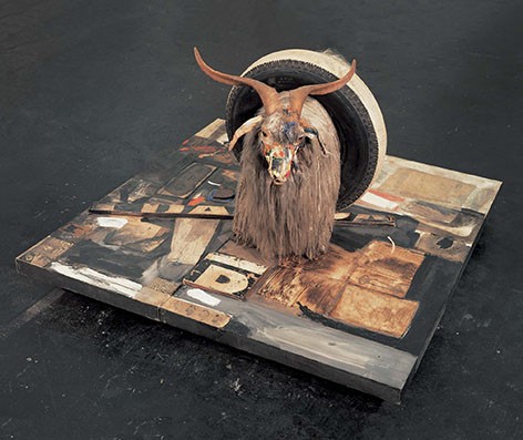Bull head with horns in a tire standing on a platform painted and lettered