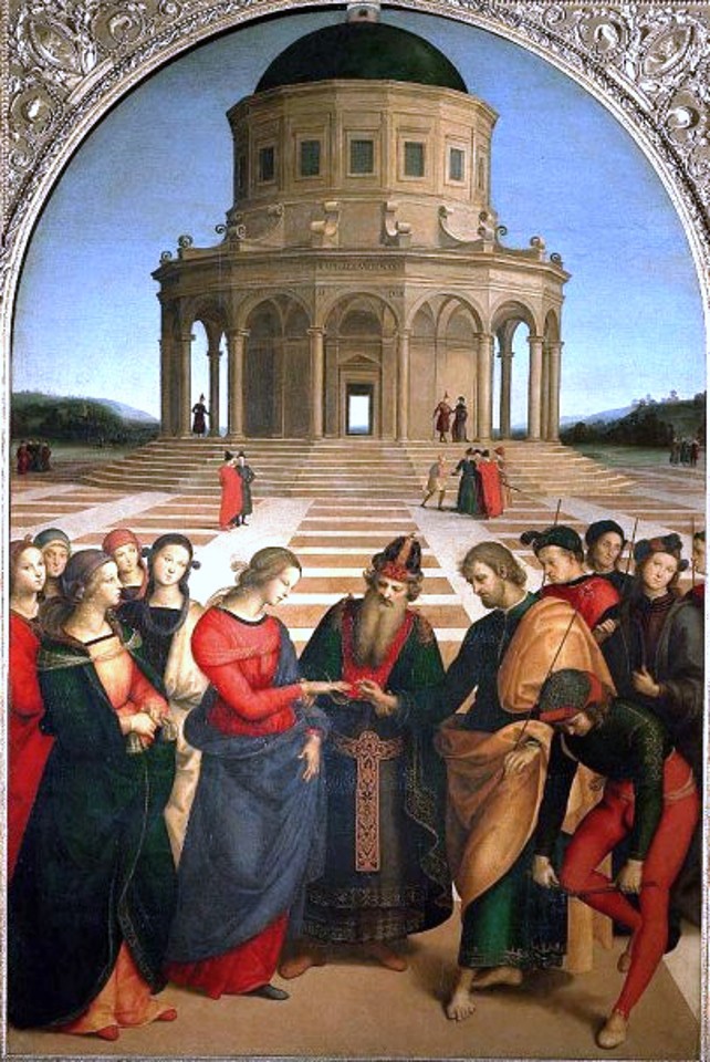 Men and women in colorful clothes watching a marriage in front of a round building