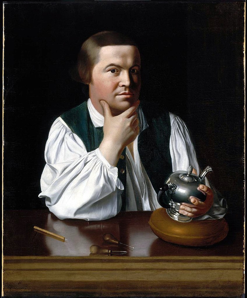 Man holding a teapot with one hand on his chin