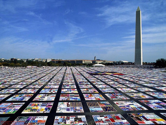 Field covered with squares of photos and patterns in front of a tall building
