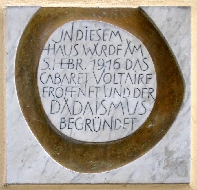 German letters carved in the white center of a brown plaque