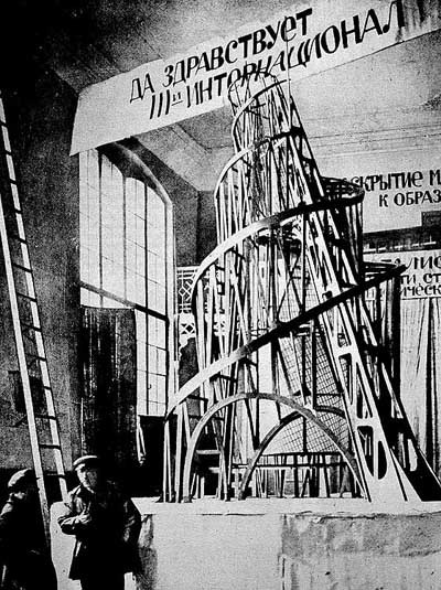 Tall winding staircase and a ladder in a room with banners on the ceiling