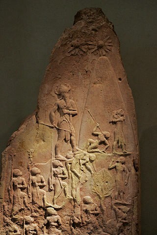Brown stone carved with images of soldiers and a king with a horned helmet