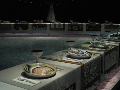 A long table lined with dishes and wine goblets over colorful table cloths