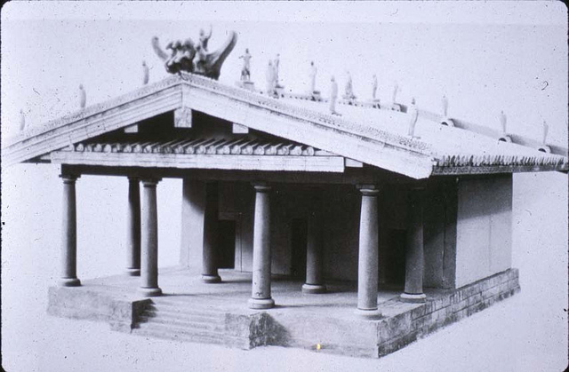Gray photo of a roof lined with statues over a porch with many pillars