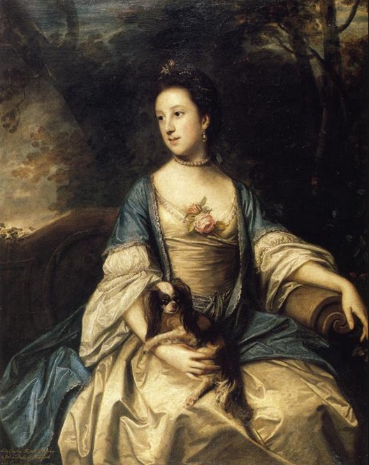 Elegant woman in a gown with a puppy in her lap, looking to the side