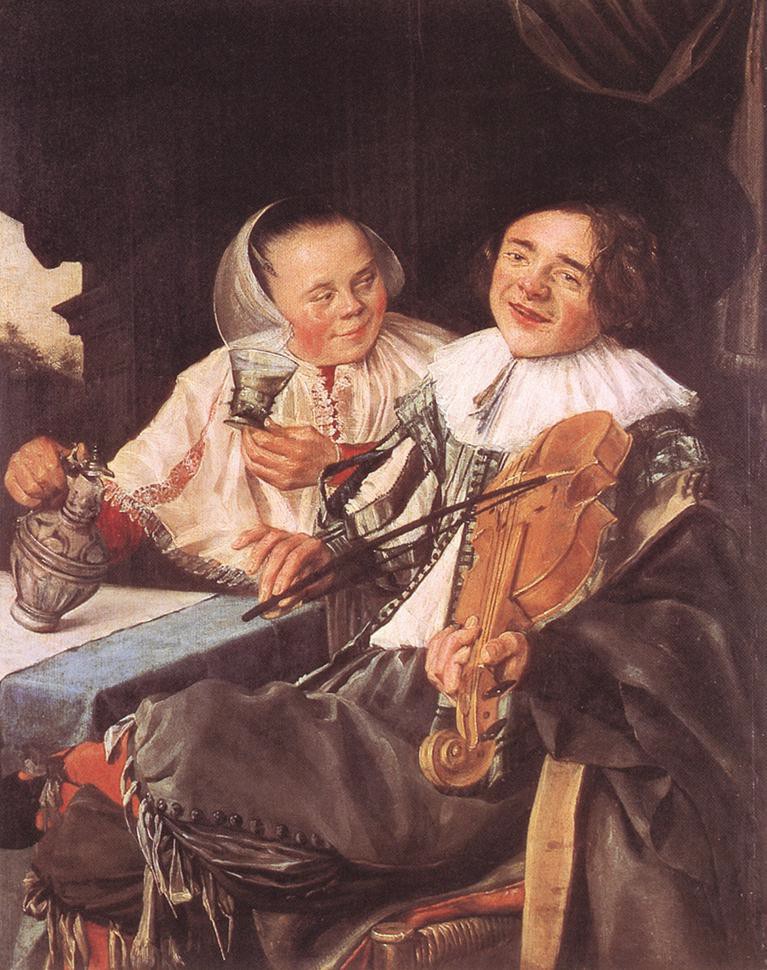 A woman with a pot seated beside a man playing a violin and smiling