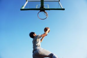 A boy jumping to dunk a basketball
