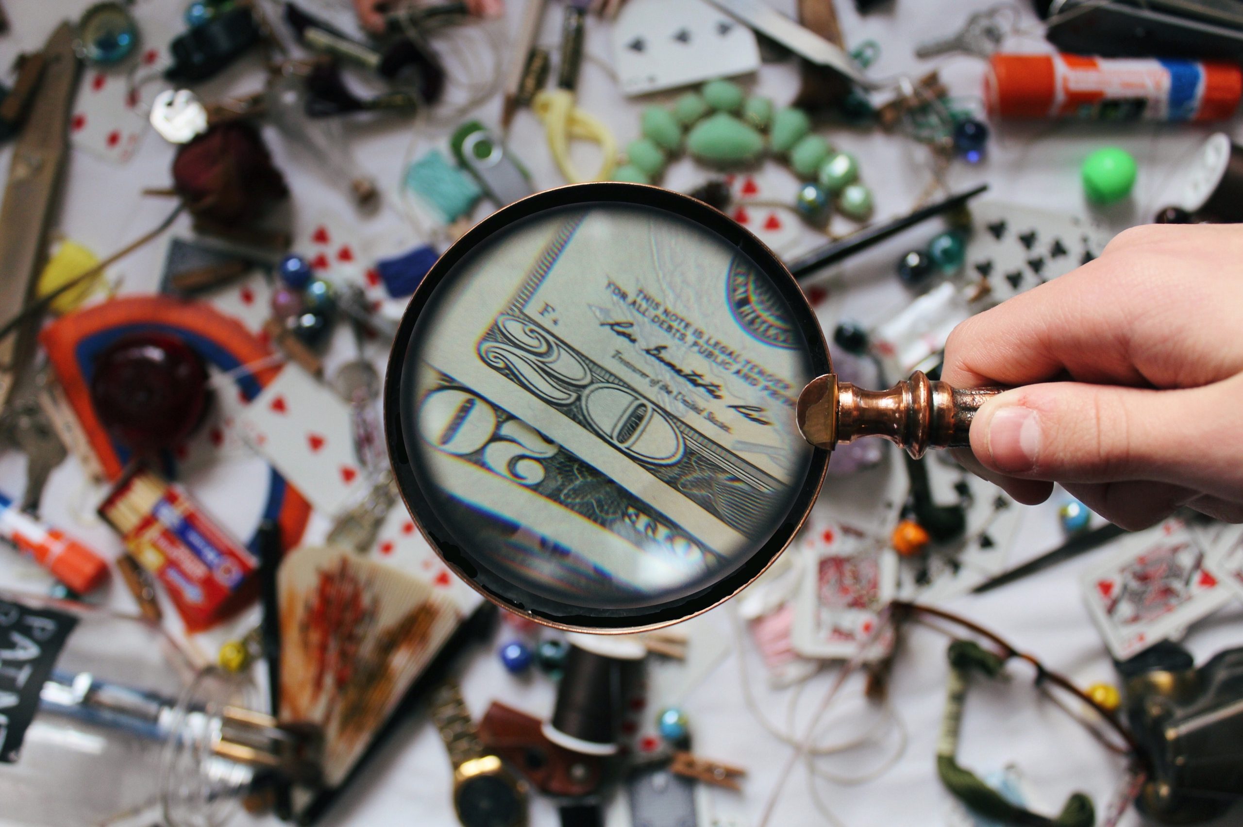 Magnifying glass looking at money and various objects