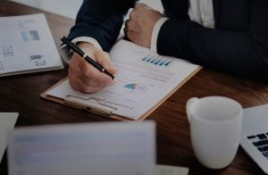 Photo of a business person's desk complete with paper, pen and coffee