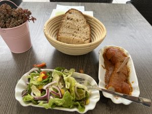 Photo of a german currywurst dinner with salad and bread.