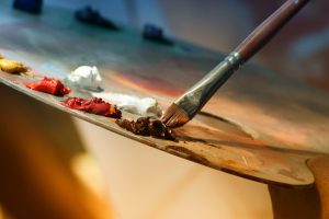 Photo of an artist's pallette, paintbrush and paint
