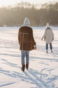 Picture of two women, ice skating on a snowy, frozen lake