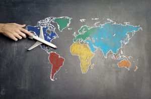 Picture of a chalk drawing of the earth and a toy plane on top of the drawing